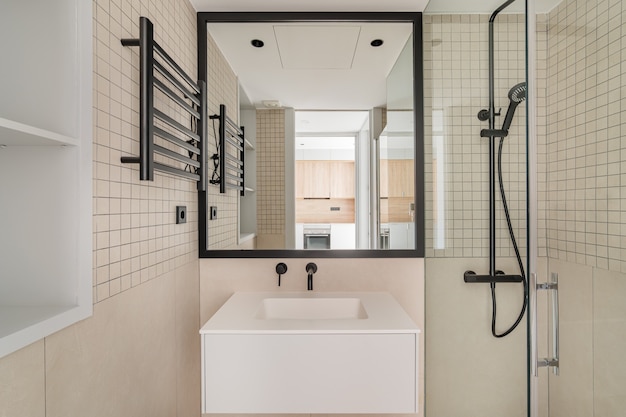 Diseño interior moderno de baño en color beige con decoración en metal negro vista frontal de baño con ...