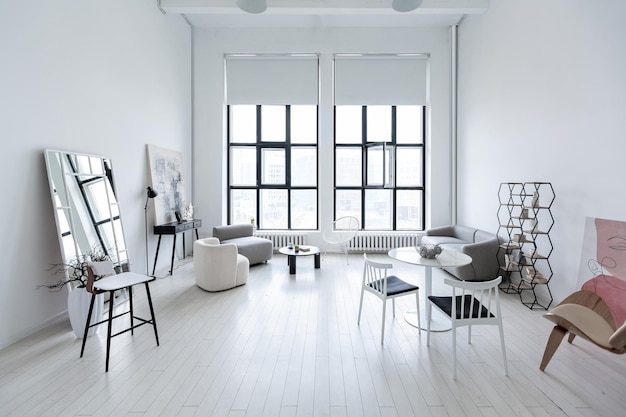 Diseño interior moderno y minimalista de habitación monocromática clara y luminosa con muebles en blanco y negro, paredes blancas limpias y ventanas enormes