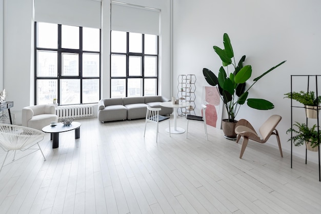 Diseño interior moderno y minimalista de habitación monocromática clara y luminosa con muebles en blanco y negro, paredes blancas limpias y ventanas enormes