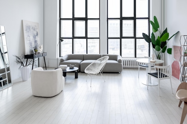 Diseño interior moderno y minimalista de habitación monocromática clara y luminosa con muebles en blanco y negro, paredes blancas limpias y ventanas enormes