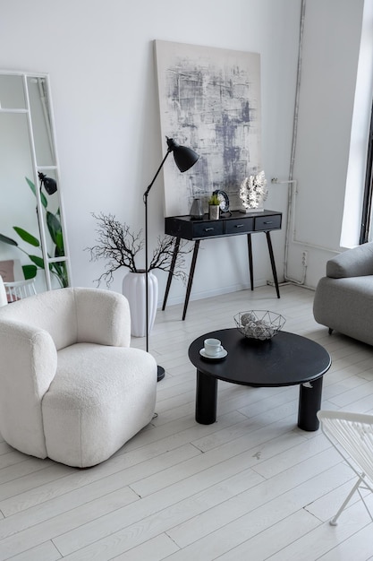 Diseño interior moderno y minimalista de habitación monocromática clara y luminosa con muebles en blanco y negro, paredes blancas limpias y ventanas enormes