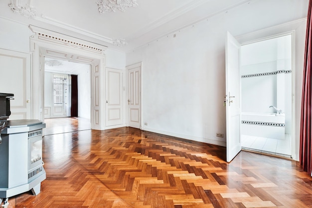 Diseño de interiores de casa clásica de amplio pasillo con paredes blancas y elementos decorativos de estuco y con piso de parquet amueblado con chimenea