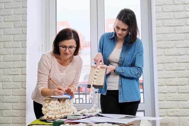 Diseño de interiores, diseñadoras que trabajan eligiendo muestras de telas y accesorios para cortinas