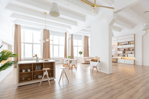 Diseño de interiores espacioso apartamento luminoso en estilo escandinavo y cálidos colores blanco pastel y beige. muebles de moda en la sala de estar y detalles modernos en el área de la cocina.