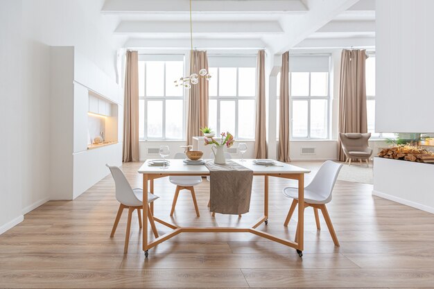 Diseño de interiores espacioso apartamento luminoso en estilo escandinavo y cálidos colores blanco pastel y beige. muebles de moda en la sala de estar y detalles modernos en el área de la cocina.