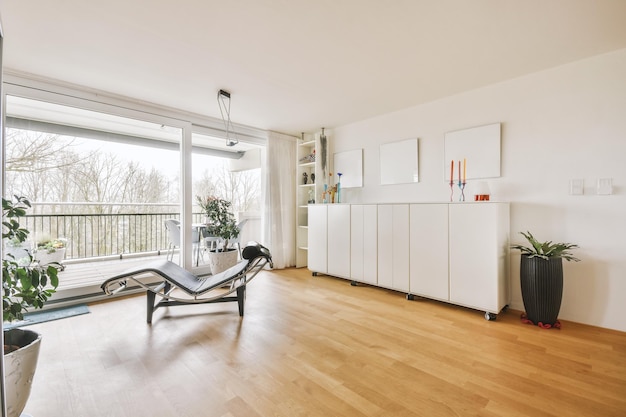 Diseño de interiores de estilo minimalista moderno de apartamento tipo estudio con cocina blanca abierta y zona de comedor con mesa y sillas