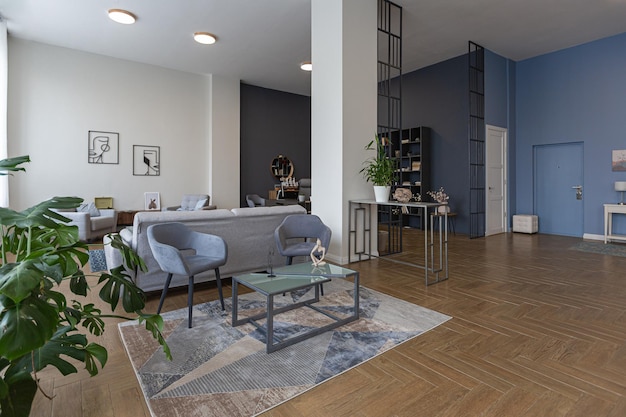 Diseño de interiores moderno y minimalista, enorme apartamento luminoso con un plan abierto en estilo escandinavo en colores azul blanco y azul oscuro con columnas en el centro, incluye área de cocina, oficina y salón