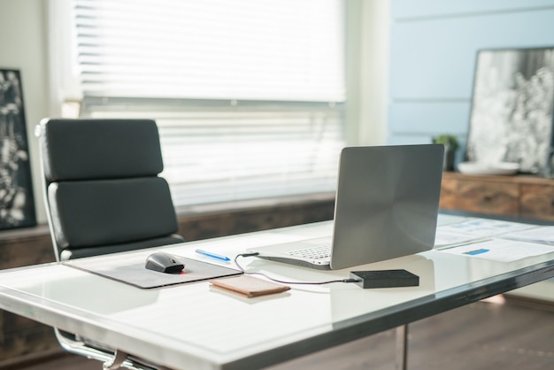 Diseño de interiores de oficina moderna con silla de oficina y escritorio frente a las ventanas Lugar de trabajo con computadora portátil