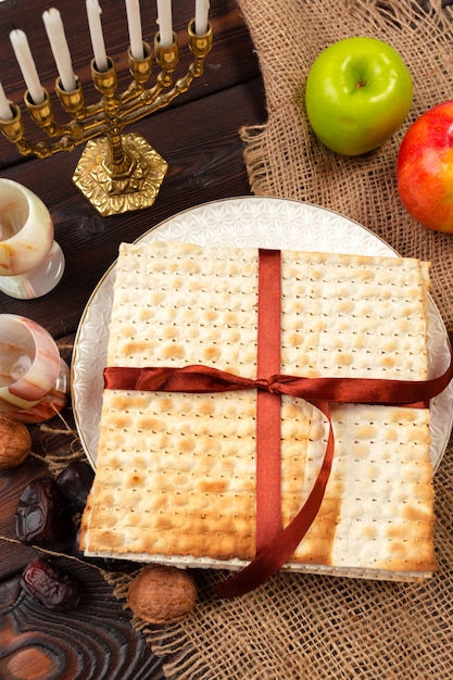 Diseño judío de la bandera de la Pascua del día de fiesta con el vino, matzo en de madera.