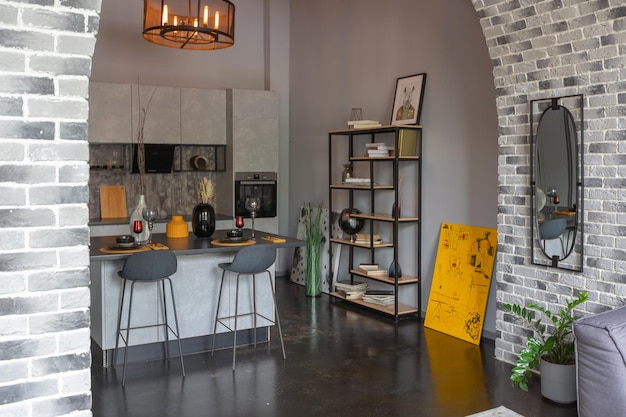 Diseño de lujo moderno de un brutal interior de apartamento con arcos al estilo de un castillo medieval con acentos brillantes una elegante zona de cocina gris con una isla para cocinar o pasar el tiempo