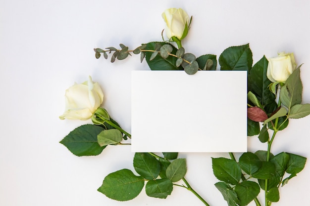 Diseño de maqueta creativa hecha con tarjeta de papel para nota de inscripción y una rosa flores. Boda plana o concepto mínimo de San Valentín.