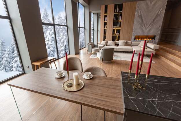 Diseño moderno y elegante de un interior oscuro y caro de una lujosa casa de campo con enormes ventanas panorámicas y una magnífica vista del bosque divino