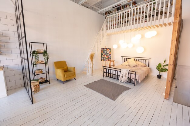 Diseño moderno de lujo de un pequeño y acogedor estudio de estilo escandinavo con paredes blancas, segundo piso con una biblioteca y una gran ventana alta llena de luz natural