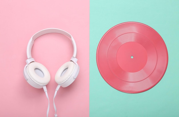 Diseño de música creativa Disco de vinilo rosa y auriculares sobre fondo rosa azul pastel Minimalismo Endecha plana Vista superior