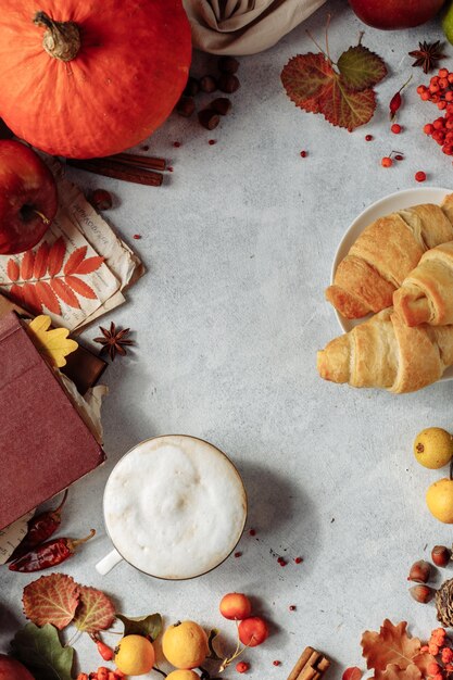 Diseño de otoño. una taza de café, calabaza, manzanas y especias se encuentran alrededor del lugar debajo del texto