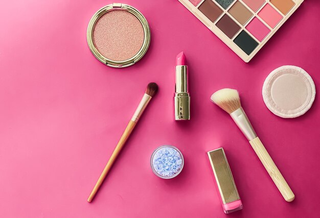 Diseño plano de maquillaje y cosméticos de belleza con productos cosméticos copyspace y herramientas de maquillaje sobre fondo rosa concepto de estilo femenino y femenino