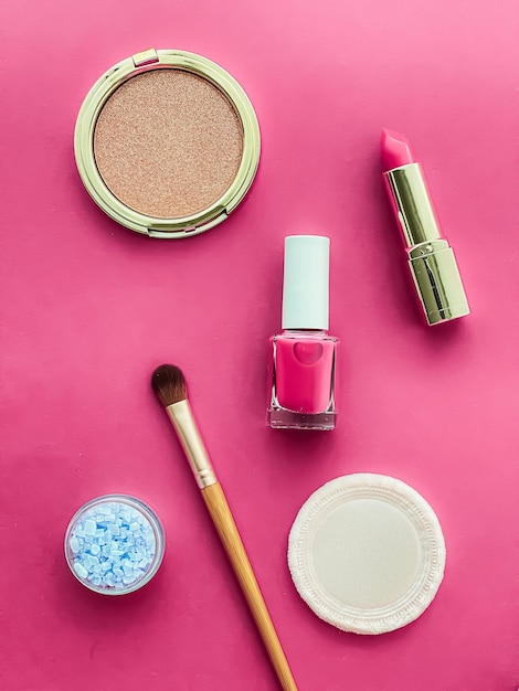 Diseño plano de maquillaje y cosméticos de belleza con productos cosméticos copyspace y herramientas de maquillaje sobre fondo rosa concepto de estilo femenino y femenino