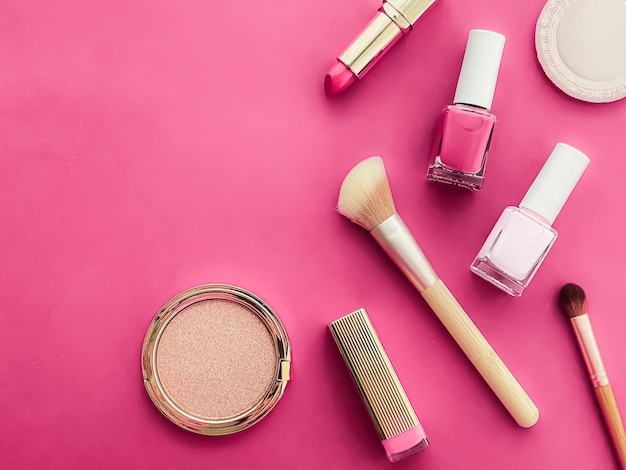 Diseño plano de maquillaje y cosméticos de belleza con productos cosméticos copyspace y herramientas de maquillaje sobre fondo rosa concepto de estilo femenino y femenino