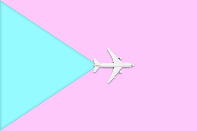 Foto diseño plano de viaje en concepto de verano vista superior de un avión en pantalla en color rosa y azul pastel en blanco con espacio de copia viaje en viaje de verano