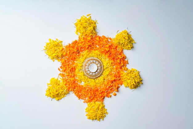 Foto diseño de rangoli de flores de caléndula con lámparas de aceite para el festival de diwali.