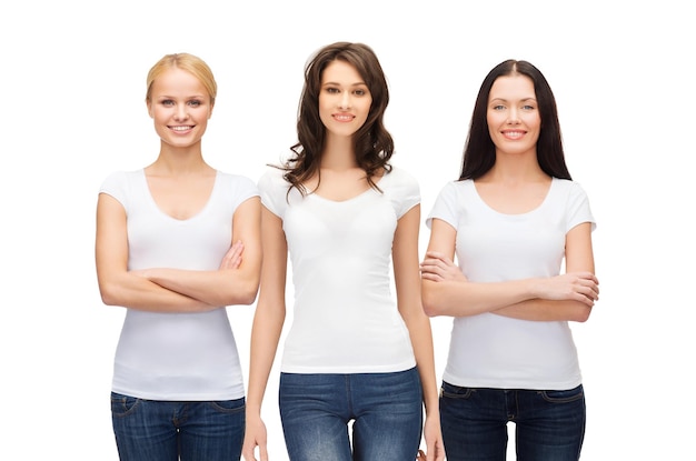 diseño de ropa y concepto de unidad de personas - grupo de mujeres sonrientes felices con camisetas y jeans blancos en blanco