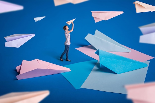 Diseño de surrealismo creativo con aviones de papel de origami Niña deja aviones de papel