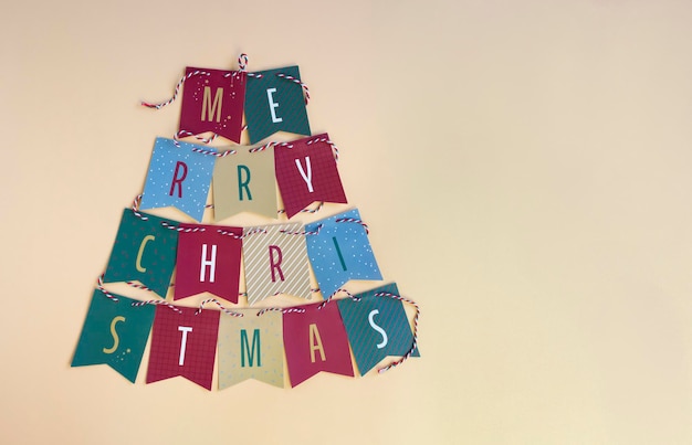 Diseño de tarjeta de banner de letras de feliz navidad con inscripción en árbol de navidad