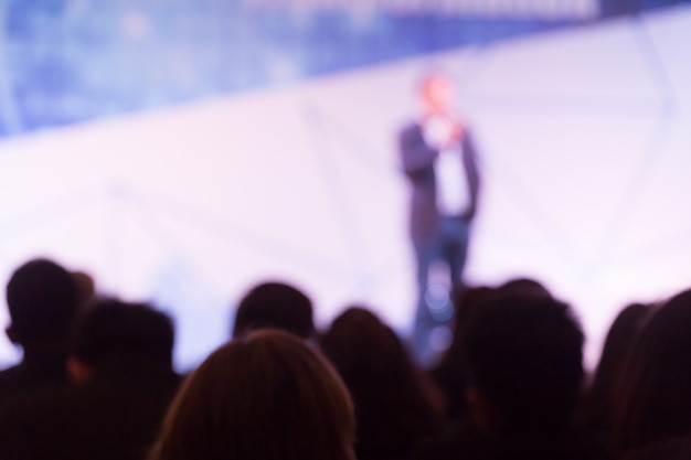 Disfocus des Sprechers, der über die Geschäftskonferenz spricht. Publikum im Konferenzsaal. Veranstaltung für Business und Entrepreneurship.