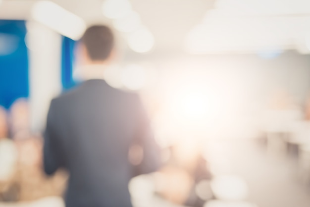 Foto disfocus do orador dando palestra sobre conferência de negócios corporativos.