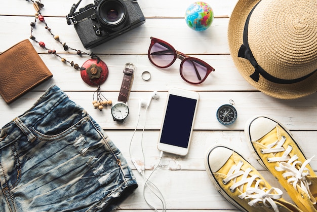 Disfraces de accesorios de viaje. Pasaportes, equipaje, el costo de los mapas de viaje preparados para el viaje, en piso de madera blanca