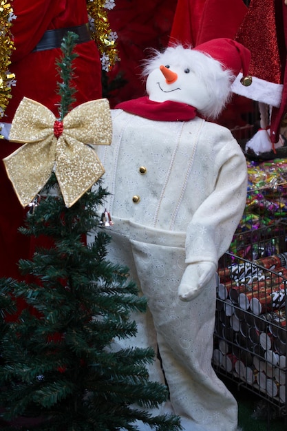 Foto disfraz de muñeco de nieve al lado de un pino