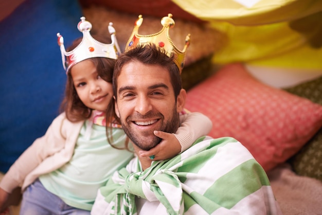 Disfrazarse de corona y papá con diversión de princesa en un dormitorio fuerte con disfraz de niña y papá juntos Juega a la felicidad del castillo y sonríe con padre e hijo en un hogar emocionado y feliz por un juego