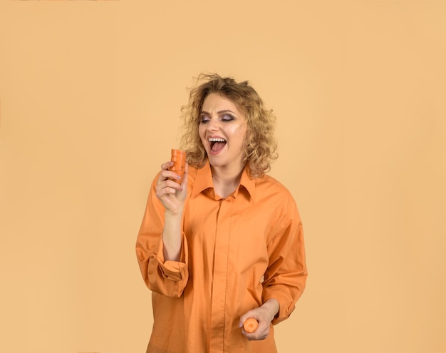 Disfrutando de alimentos saludables hermosa niña comiendo zanahoria vegetal que tiene un buen impacto en los dientes sonriendo