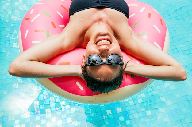 Disfrutando de bronceado mujer en bikini en el colchón inflable