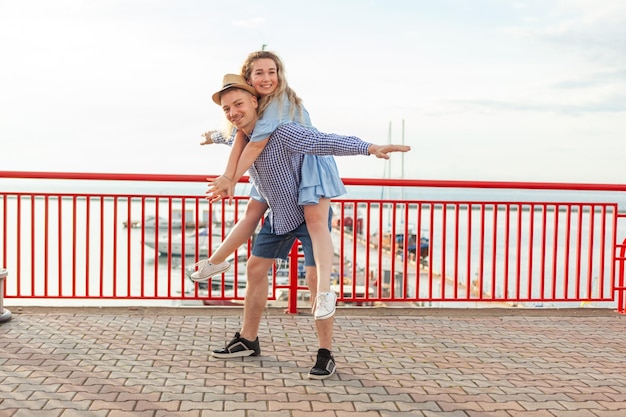 Disfrutando de cada momento juntos. Una joven pareja enamorada divirtiéndose al aire libre mientras un hombre guapo le da a su novia un paseo en un cerdo. Concepto romántico y amoroso