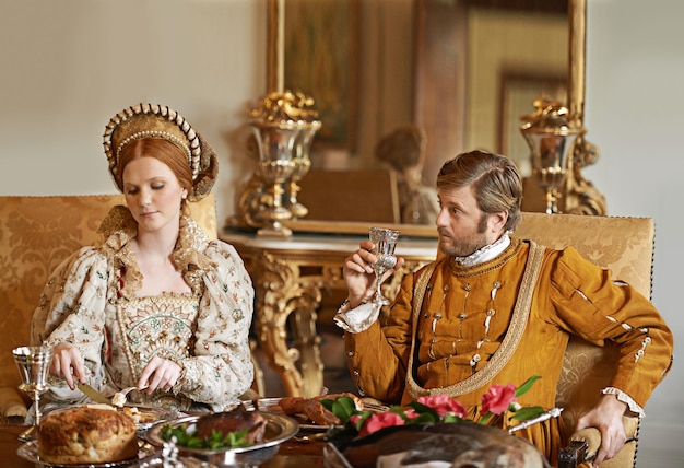 Disfrutando de la comodidad del palacio Toma de una pareja noble comiendo juntos