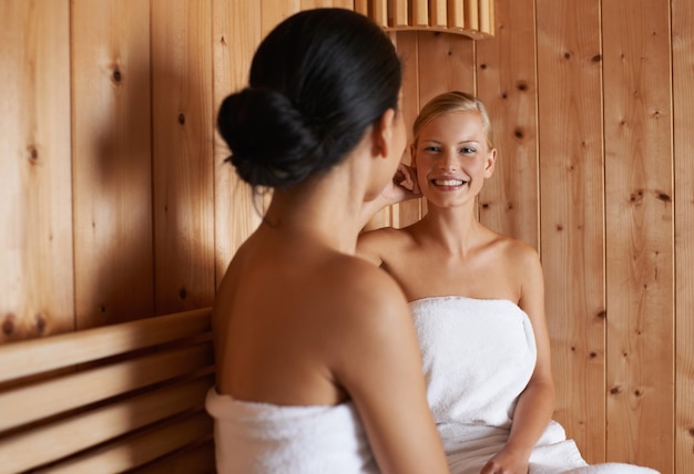 Disfrutando de un día de mimos Dos amigos relajándose juntos en la sauna