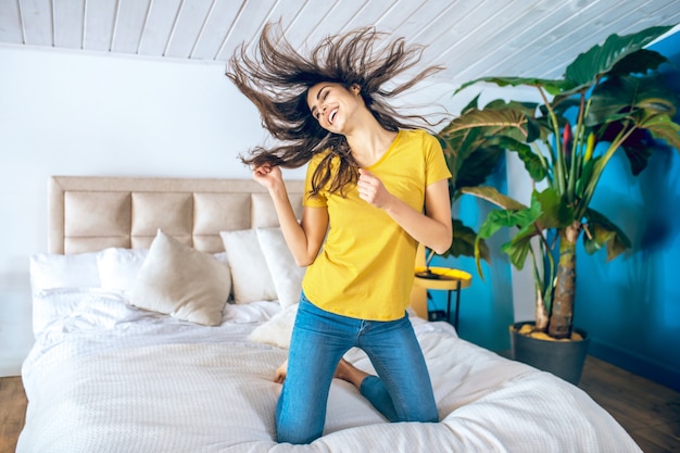 Disfrutando. Mujer joven hermosa de pelo largo que parece alegre y emocionada