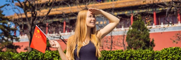 Disfrutando de vacaciones en china mujer joven con bandera nacional china en ciudad prohibida viajar a china