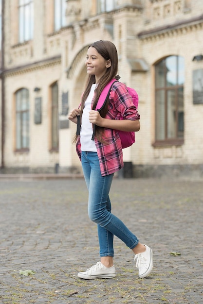 Disfrutando de la vida del alumno. Alumno femenino en estilo casual al aire libre. El niño pequeño va a la escuela. Educación primaria. Ella nunca se salta ninguna clase.