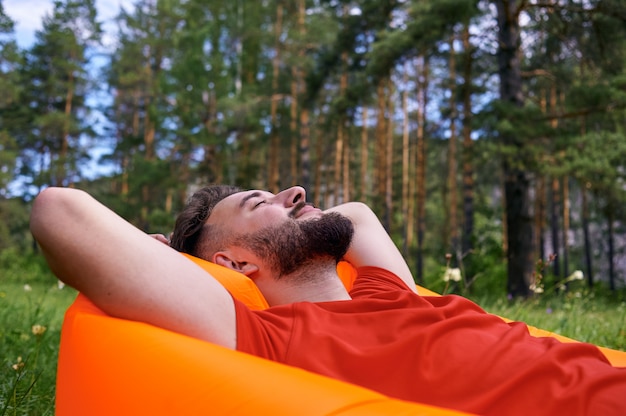 Foto disfrutando de la vida. un joven se encuentra en un campamento en el bosque, relajación, vacaciones, concepto de estilo de vida