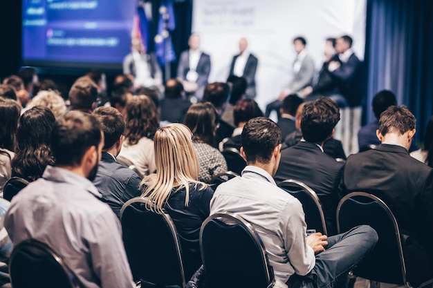 Diskussion am runden Tisch bei einer Geschäftskonferenz mit Veranstaltungspublikum im Konferenzsaal