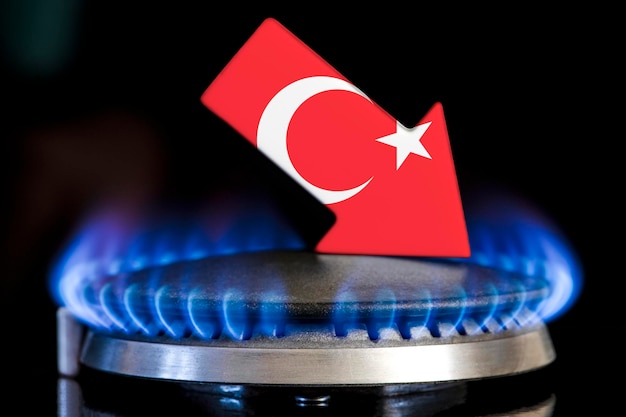 Disminución del suministro de gas en Turquía Una estufa de gas con una llama ardiente y una flecha con los colores de la bandera de Turquía apuntando hacia abajo Concepto de crisis en invierno y falta de gas natural Temporada de calefacción