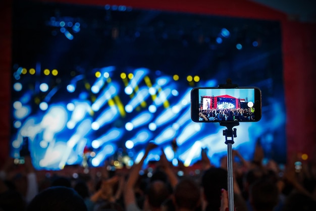 Foto disparar concierto de rock por teléfono inteligente en selfie stick