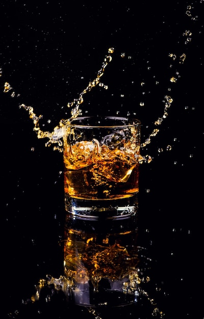 Disparo aislado de whisky con splash sobre fondo negro