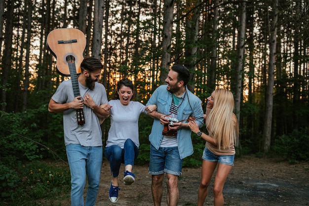 Disparo de amigos felices divirtiéndose en el bosque