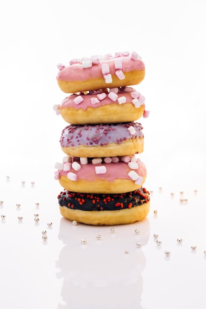 Disparo de cinco donas dulces apiladas una encima de la otra en forma de torre sabrosa deliciosa swe