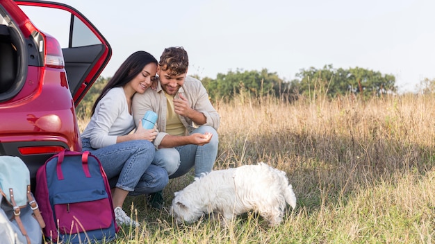 Foto disparo completo feliz pareja mirando perro