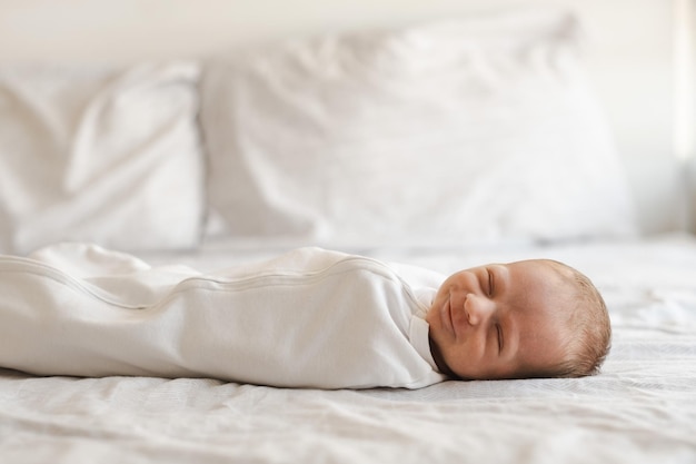 Disparo de cuerpo completo de sonriente caucásico peludo brunet lindo bebé recién nacido durmiendo vistiendo blanco drawsheetOne o dos semanas de edad pocos días niño