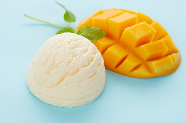 Disparo de enfoque selectivo de delicioso helado con mango aislado en una superficie azul